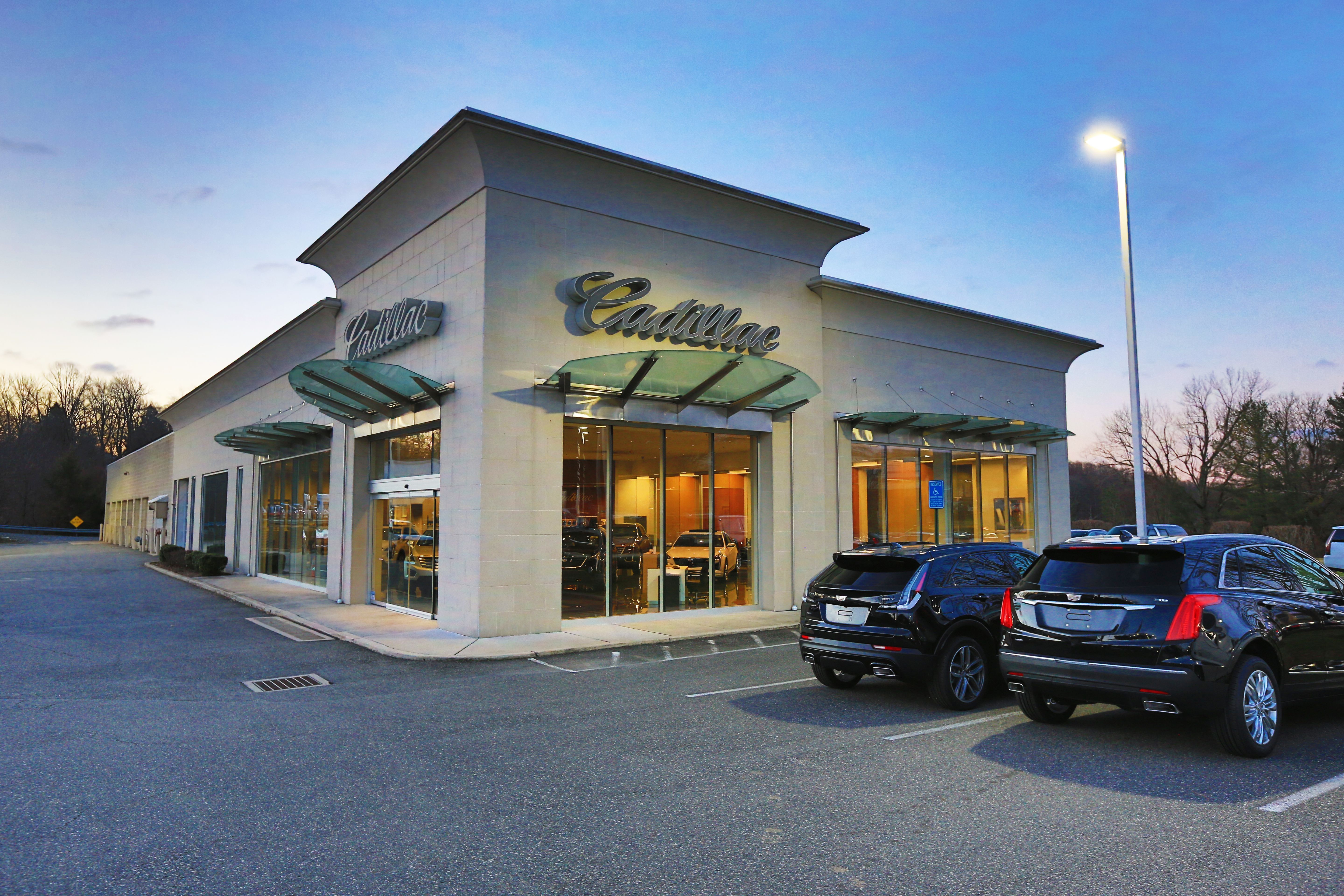 Picture of the outside of a Cadillac dealership lot.